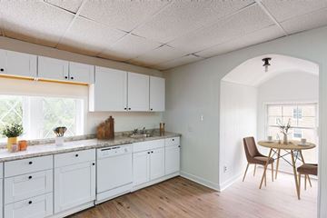 Kansas City apartment for rent - A kitchen with white cabinets and a table with chairs.