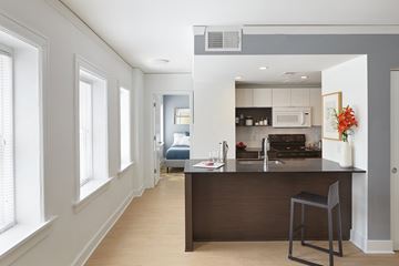 Kansas City apartment for rent - A kitchen with a bar stool in front of a counter.