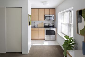 Kansas City apartment for rent - A modern kitchen with wooden cabinets and stainless steel appliances.
