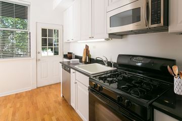 Chicago apartment for rent - A kitchen with a black stove top oven and white cabinets.