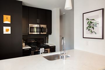 Kansas City apartment for rent - A modern kitchen with a stainless steel stove and microwave.