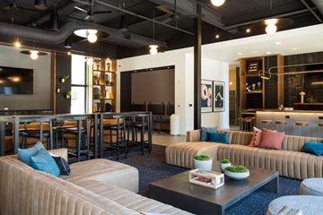 Kansas City apartment for rent - A modern living room with a large couch and a coffee table.