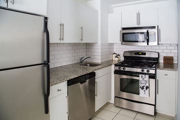 Kansas City apartment for rent - A kitchen with a refrigerator, microwave, oven, and dishwasher.