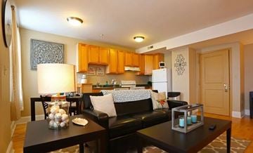 St. Louis apartment for rent - A living room with a black couch and a coffee table with a candle holder on it.