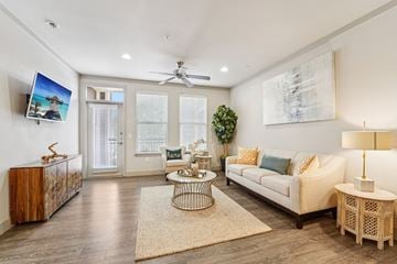 Kingwood apartment for rent - A living room with a white couch, a wooden cabinet, a coffee table, and a painting on the wall.