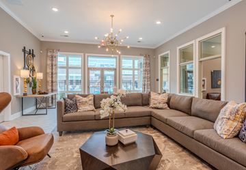 Clayton apartment for rent - A living room with a large sectional sofa and a coffee table in front of a large window.