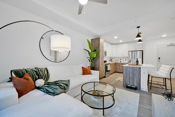 Tampa apartment for rent - A modern living room with a white couch and a glass coffee table.