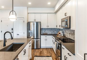 West Palm apartment for rent - A modern kitchen with white cabinets and a stainless steel refrigerator.