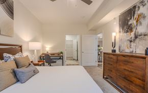 Clayton apartment for rent - A bedroom with a large bed and a painting on the wall.