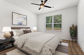 Lawrenceville apartment for rent - A bedroom with a bed, a ceiling fan, and a window with blinds.