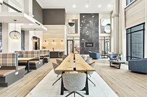 Alpharetta apartment for rent - A modern dining area with a long wooden table and grey chairs.