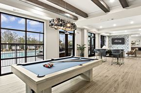 Alpharetta apartment for rent - A billiard table is in the middle of a room with a pool table and a bar.
