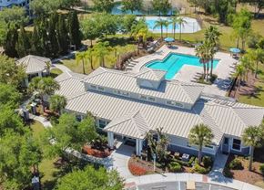 New Port Richey apartment for rent - a house with a pool and trees in the background