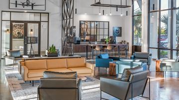 Fort Myers apartment for rent - A modern living room with a large sofa and a glass table.