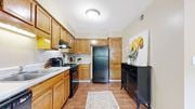 Dunwoody apartment for rent - a kitchen with wooden cabinets and black appliances