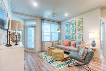 Corpus Christi apartment for rent - A living room with a grey sofa and a wicker ottoman.