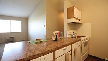 Columbus apartment for rent - A kitchen with a brown counter top and white cabinets.