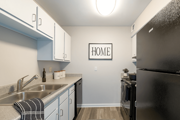 Crestwood apartment for rent - A kitchen with a black refrigerator and a sign that says "HOME".