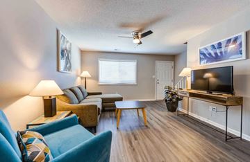 Greenwood apartment for rent - A living room with a blue couch and a television.