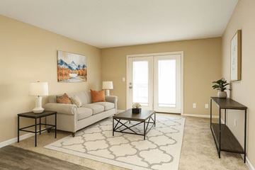 Louisville apartment for rent - A living room with a grey couch, a coffee table, and a painting on the wall.