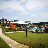 Tyler apartment for rent - A playground with a slide and a pool in the background.