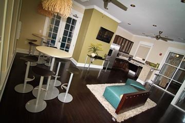 Tyler apartment for rent - A living room with a green couch and a dining table with chairs.