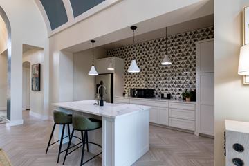 Corinth apartment for rent - A kitchen with a white counter and green bar stools.