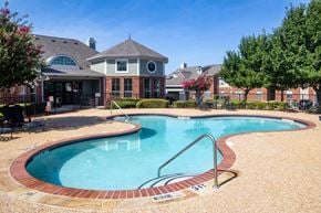 Corinth apartment for rent - A swimming pool with a brick border and a slide.