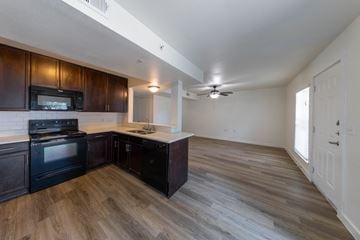 Denton apartment for rent - A kitchen with dark wood cabinets and a black stove top oven.