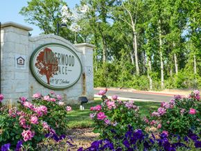 Longview apartment for rent - A sign for Amerwood Place surrounded by flowers.