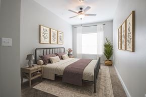 Abilene apartment for rent - A bedroom with a bed, nightstand, and a ceiling fan.