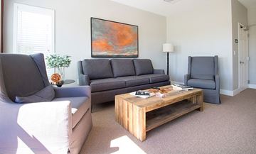 Abilene apartment for rent - A living room with a grey couch, a wooden coffee table, and a painting on the wall.