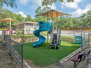 Austin apartment for rent - A playground with a blue slide and a yellow umbrella.