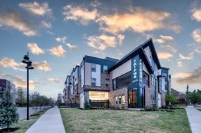 Dallas apartment for rent - A modern apartment building with a well-maintained lawn in front.