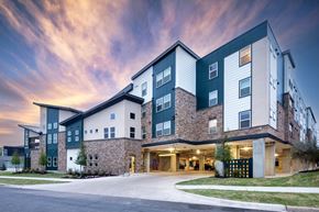 Dallas apartment for rent - A modern apartment building with a mix of green and beige exterior colors.