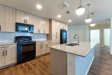 Austin apartment for rent - A kitchen with wooden cabinets and a granite countertop.