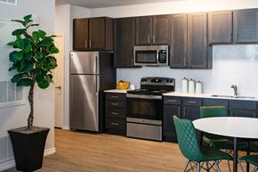 Georgetown apartment for rent - A kitchen with a stainless steel refrigerator, a microwave above the stove, and a dining table with chairs.