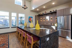 Arlington apartment for rent - A kitchen with a black counter top and wooden chairs.