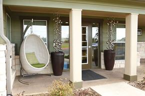 Abilene apartment for rent - A white chair with a green cushion is on the porch of a house.