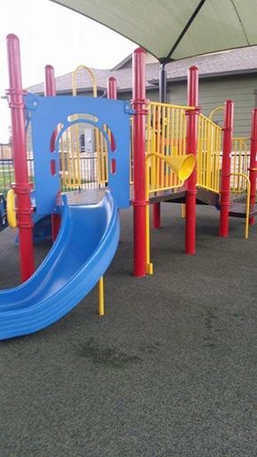 Abilene apartment for rent - A playground with a blue slide and red and yellow poles.
