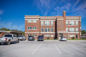 Abilene apartment for rent - A parking lot with cars and a building in the background.