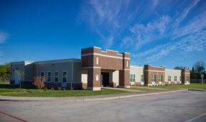 Abilene apartment for rent - A large building with a parking lot in front.