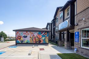 Grand Prairie apartment for rent - A building with a mural on the side and a sign that says "Blue Plate".