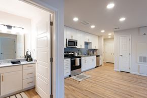 Grand Prairie apartment for rent - A kitchen with white cabinets and a wooden floor.