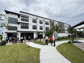 Ft Myers apartment for rent - A group of people are standing outside a modern building.