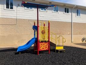 Tyler apartment for rent - A playground with a blue slide and a red and yellow structure.