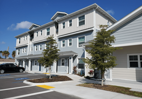 Bradenton apartment for rent - A white building with a grey roof and a black car parked in front.