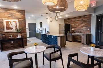 Ft. Worth apartment for rent - A modern kitchen with a brick wall and a dining table with chairs.