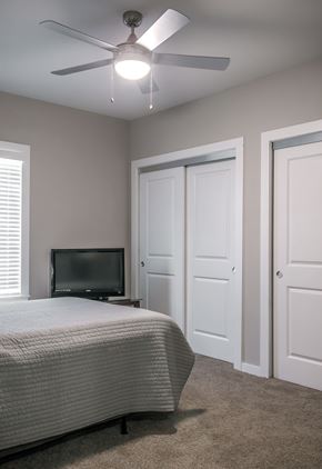 Kerrville apartment for rent - A bedroom with a bed, television, and two doors.