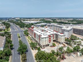 Austin apartment for rent - A road with cars and a building with red and white stripes.